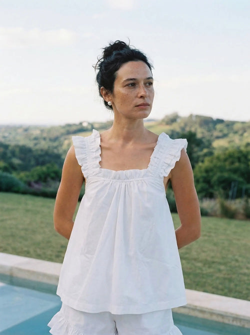 Front view of a model wearing the white bridal pyjama set made from 100% washed cotton with feminine ruffle straps.